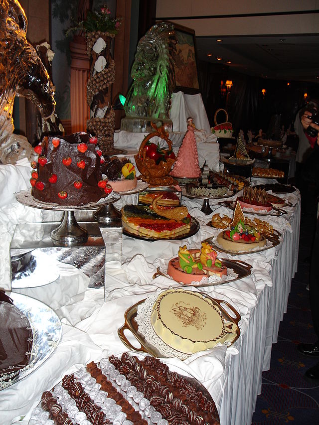 Midnight buffet hosted on Celebrity Cruise. White tablecloth with different desserts on the table. 