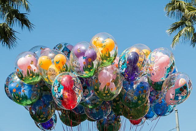 Pink, purple, yellow, red, and blue glasshouse Mickey balloons alongside green standard balloons.