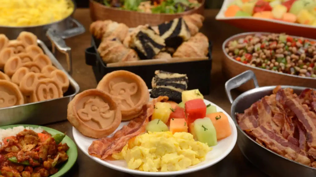 Breakfast food available at Tusker House Restaurant in Animal Kingdom. Waffles with Simba the Lion Cub on them; Fresh Fruit like Watermelon, Honeydew, and Cantaloupe; Scrambled Eggs; Bacon, Black and White Pastry;