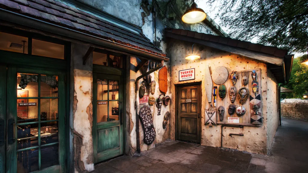 Outside of Tusker House Restaurant. Beige building with African Masks and other Artifacts.
